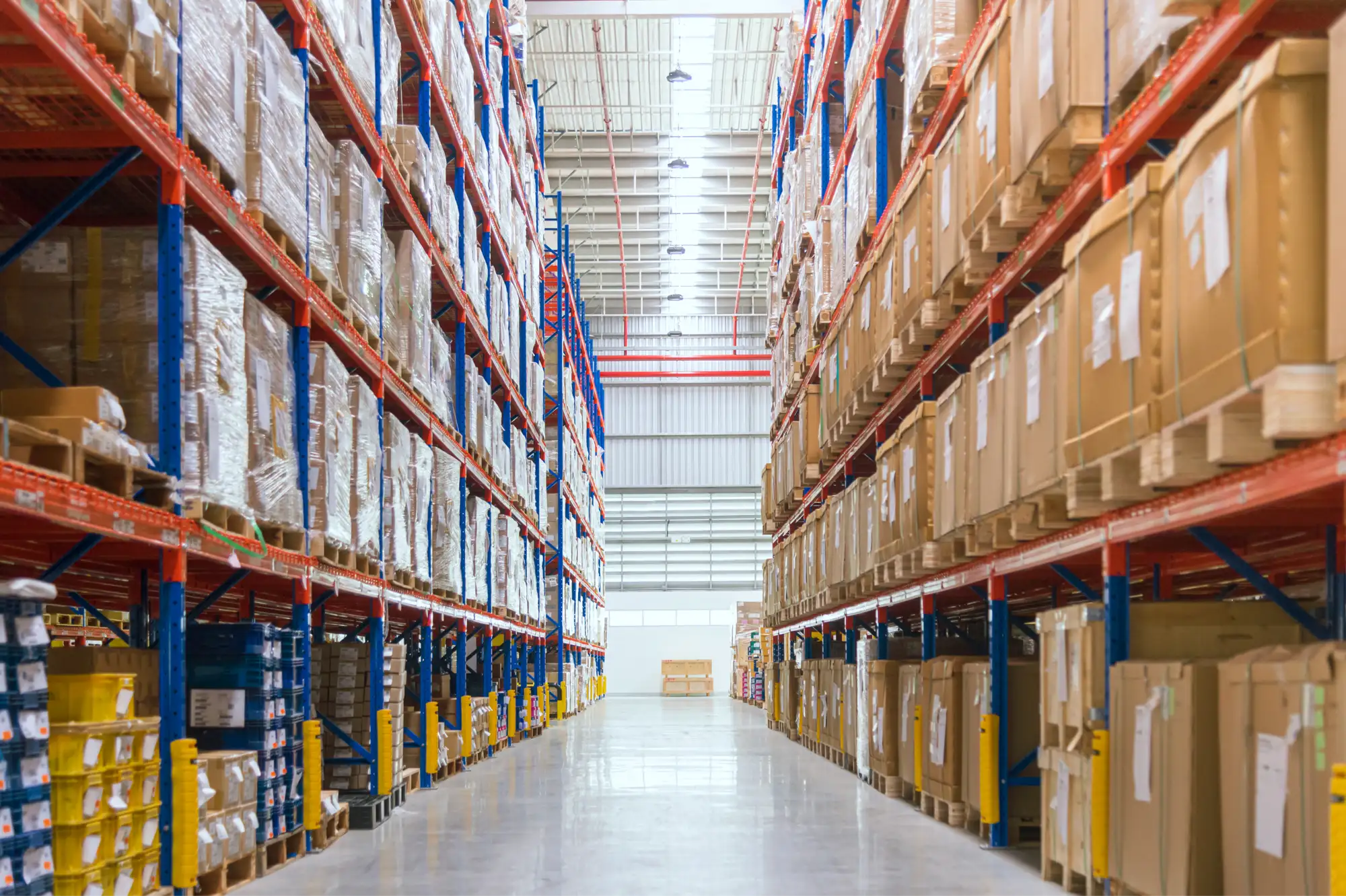 Tall warehouse aisle lined with stocked shelving